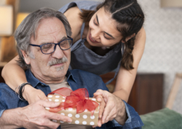 Senior receiving a gift from his daughter