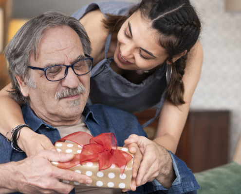 Senior receiving a gift from his daughter