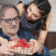 Senior receiving a gift from his daughter