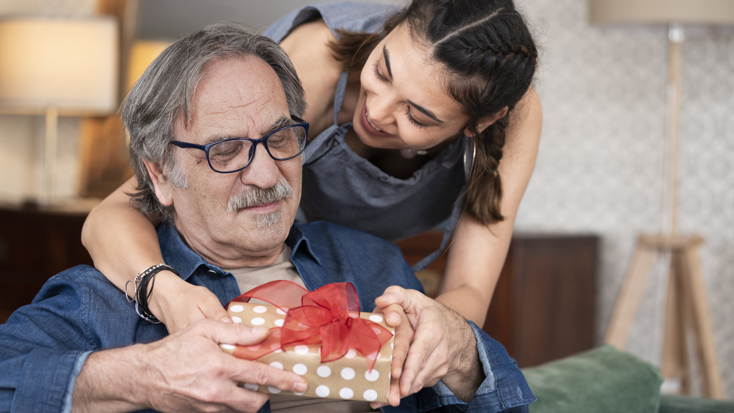 Senior receiving a gift from his daughter