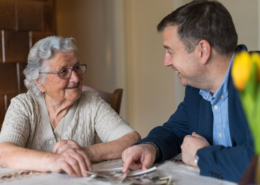 Senior Looking at Photos with Family Member