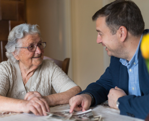 Senior Looking at Photos with Family Member