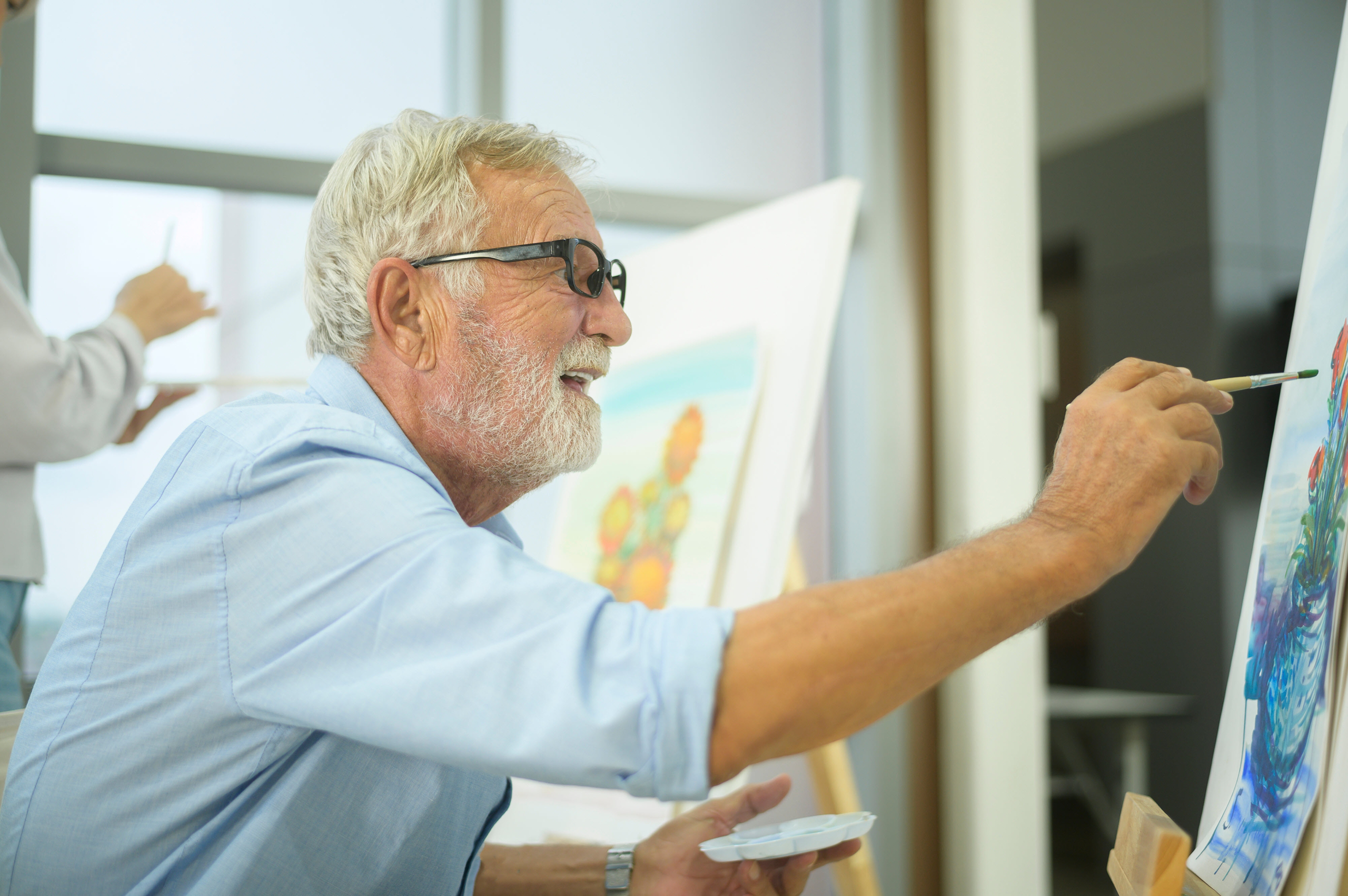 Senior in memory care painting a portrait
