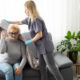 A professional caregiver helps an older woman with a blanket at home, illustrating personalized senior care and nursing home alternatives.
