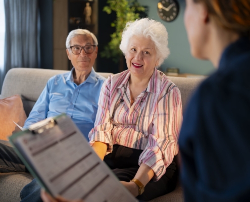 Older couple meets with a senior living advisor to review admission paperwork and assisted living community fee refund policies.